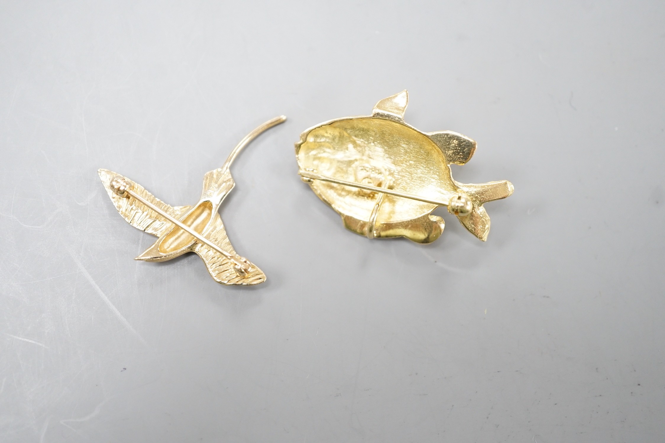 A 14k yellow metal bird brooch modelled as a Bermuda Longtail, 31mm, 2.9 grams and an Astwood Dickenson 18ct fish pendant brooch, 6.5 grams.